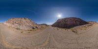 a 360 - view image of a deserted, desert road that stretches the length of a rock cliff