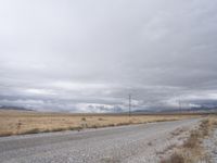 a deserted and empty road stretches out in the distance on a cloudy day in the desert