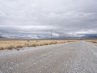 a deserted and empty road stretches out in the distance on a cloudy day in the desert