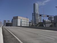 a deserted street with lots of buildings in the distance and tall buildings on both sides