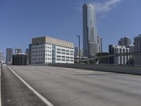 a deserted street with lots of buildings in the distance and tall buildings on both sides