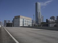 a deserted street with lots of buildings in the distance and tall buildings on both sides