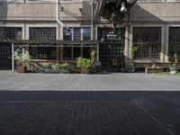 the entrance is next to the street outside of a building with chairs and umbrellas