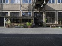 the entrance is next to the street outside of a building with chairs and umbrellas