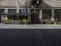 the entrance is next to the street outside of a building with chairs and umbrellas