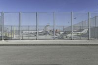 a fence is at an airport as the plane prepares to take off from the runway