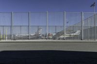 a fence is at an airport as the plane prepares to take off from the runway