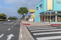 a blue building and a yellow store are on the corner of the street with two white arrow arrows