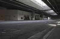 the streets under a bridge and sidewalk of an area with no cars, street lamps and a fire hydrant