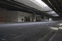 the streets under a bridge and sidewalk of an area with no cars, street lamps and a fire hydrant