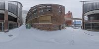 a view of an old industrial building through a very distorted lens lens with snow on the ground and in the foreground