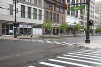 city street scene with many buildings and a red light on corner of street with crosswalk on one side