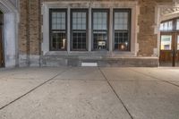 a large stone step that is in front of a building with lots of windows and a fire hydrant