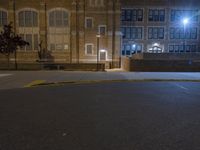 a street light on a dark and empty street by a high school building in the city