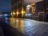 a street in the middle of an old brick street at night with neon lighting from several lights