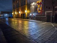 a street in the middle of an old brick street at night with neon lighting from several lights