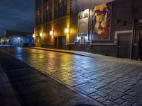 a street in the middle of an old brick street at night with neon lighting from several lights