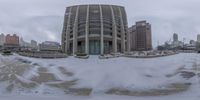 an image of a big building surrounded by snow on a cloudy day and the building is in front of it