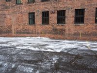 a street is covered in snow on an urban building street curb with building windows and red fire hydrant