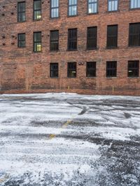 a street is covered in snow on an urban building street curb with building windows and red fire hydrant