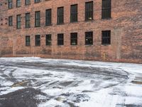 a street is covered in snow on an urban building street curb with building windows and red fire hydrant