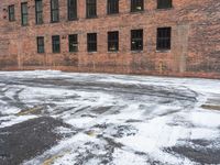 a street is covered in snow on an urban building street curb with building windows and red fire hydrant
