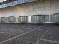 two empty parking spaces with two empty doors and a large window on the wall between two buildings