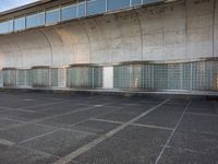 two empty parking spaces with two empty doors and a large window on the wall between two buildings