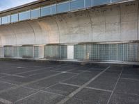 two empty parking spaces with two empty doors and a large window on the wall between two buildings