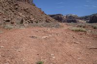 a dirt path leading through a rocky canyon in the mountains of utah, with tall brown rocks