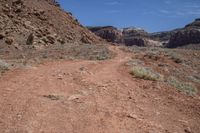 a dirt path leading through a rocky canyon in the mountains of utah, with tall brown rocks