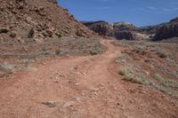 a dirt path leading through a rocky canyon in the mountains of utah, with tall brown rocks