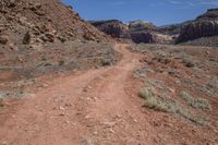 a dirt path leading through a rocky canyon in the mountains of utah, with tall brown rocks