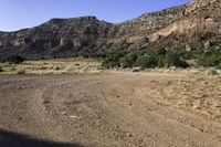 an open dirt road leads through a barren landscape and into a mountainous valley, with a truck on it