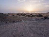 a truck on a dirt road in the desert with rocks and stones on the ground