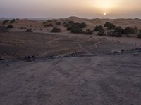 a truck on a dirt road in the desert with rocks and stones on the ground