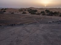 a truck on a dirt road in the desert with rocks and stones on the ground