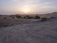 a truck on a dirt road in the desert with rocks and stones on the ground