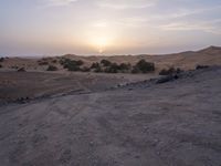 a truck on a dirt road in the desert with rocks and stones on the ground