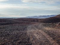 a dirt road running through an outcropping, in the middle of the desert