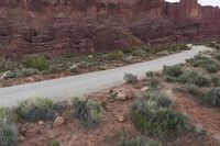 a view of the road in the desert from a distance with vegetation and rocks below