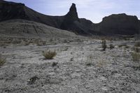 a dirt road is shown in front of an eroded mountain slope with the trail in the middle