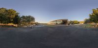 a 360 - degree photo shows an intersection on a dirt road with a few trees