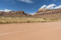 this is a dirt road and two motorcycles in the desert near a cliff wallpaper