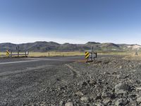 the roadway is empty on both sides of the desert as there are mountains in the distance