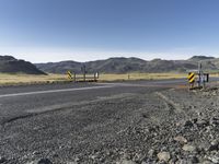 the roadway is empty on both sides of the desert as there are mountains in the distance