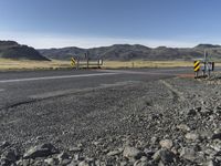 the roadway is empty on both sides of the desert as there are mountains in the distance