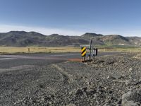 the roadway is empty on both sides of the desert as there are mountains in the distance