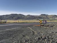 the roadway is empty on both sides of the desert as there are mountains in the distance