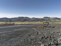 the roadway is empty on both sides of the desert as there are mountains in the distance